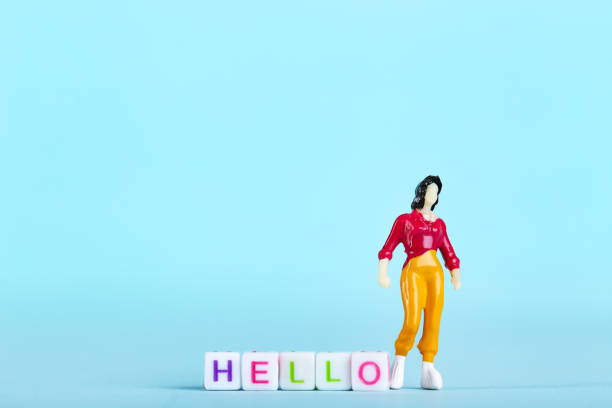 istock Miniature people and white cubes with text Hello on blue background 2148048497