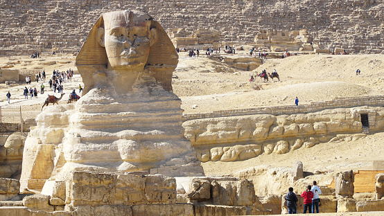 Full profile of Great Sphinx including pyramids of Menkaure and Khafre in the background on a clear sunny, blue sky day in Giza, Cairo, Egypt with no people