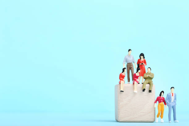 istock Miniature people with wooden cube on blue background 2148048682