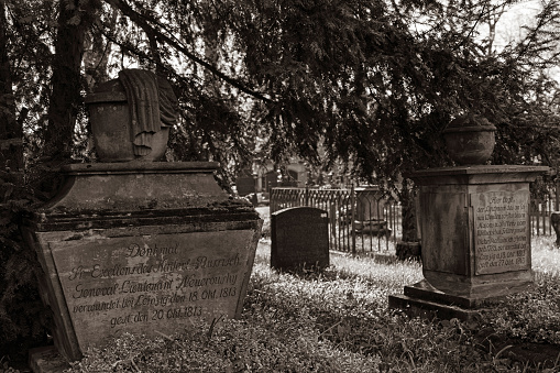 graves of soldiers who were killed in the battle of Nations near leipzig in 1813 at the Stadtgottesacker - a cemetery in Camposanto style - in Halle in a sepia black and white picture