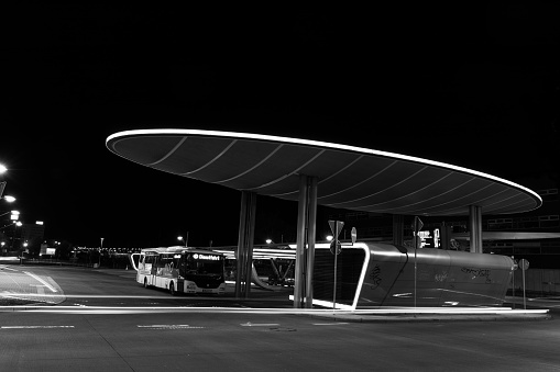 illuminated modern central bus station in Halle an der Saale at night in a black and white picture