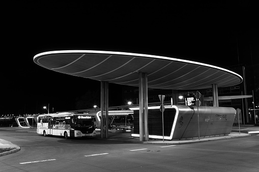 illuminated modern central bus station in Halle an der Saale at night in a black and white picture
