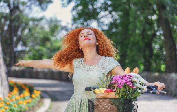 Shot of pretty young woman with a bike enjoying a springtime while going to market for grocery shopping