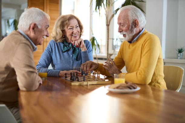 istock Happy senior friends playing chess at home 2148055997