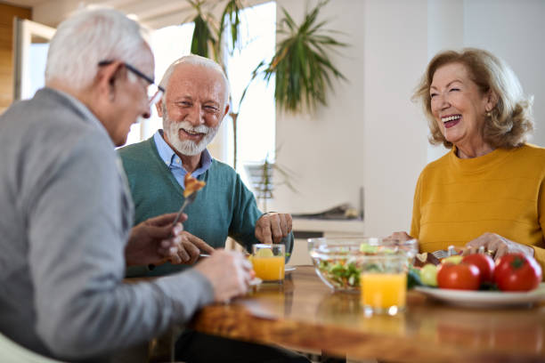 istock Group of happy seniors talking while having a meal at dining table. 2148056075