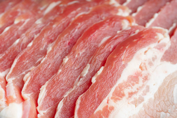 Raw pork bacon texture background close up. Streaky brisket slices, fresh thin sliced bacon meat, food ingredient