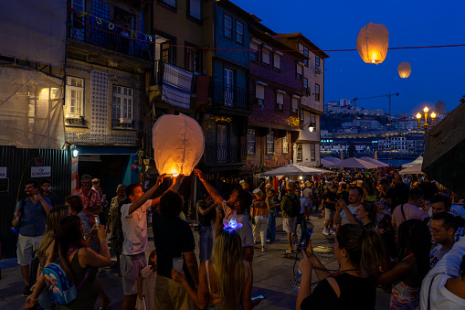 06.23.2023. Porto, Portugal: Festa de Sao Joao do Porto many happy people on the street with flying lanterns in the evening .