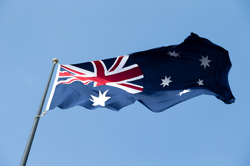 Australian flag against blue sky. High quality photo.