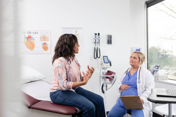 istock Mature female patient gestures while describing her symptoms 2148059175