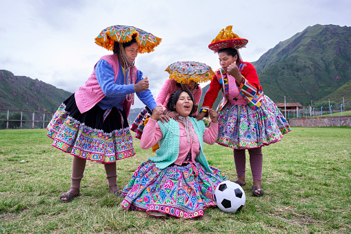 Quechua women soccer players from the Cusco region in Peru celebrating a goal on the soccer field