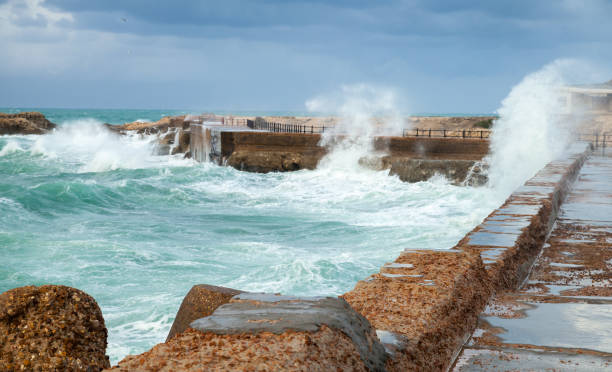 Coastal landscape with coastal stone fortifications and breaking waves