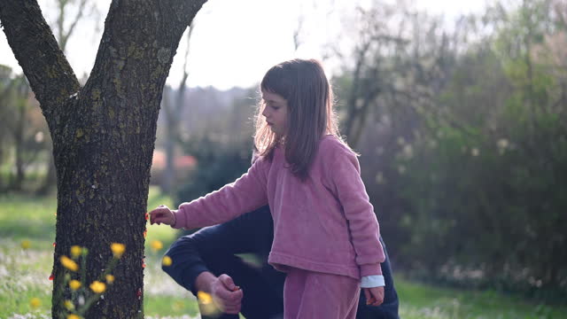 Father with daughter discovering nature in a spring park.