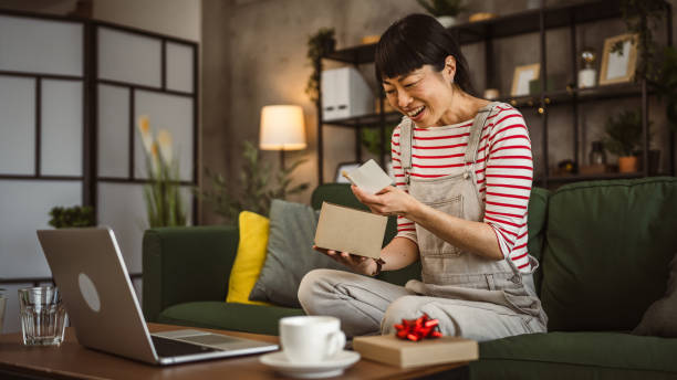 istock one mature woman open box presents and read card while on video call 2148065090