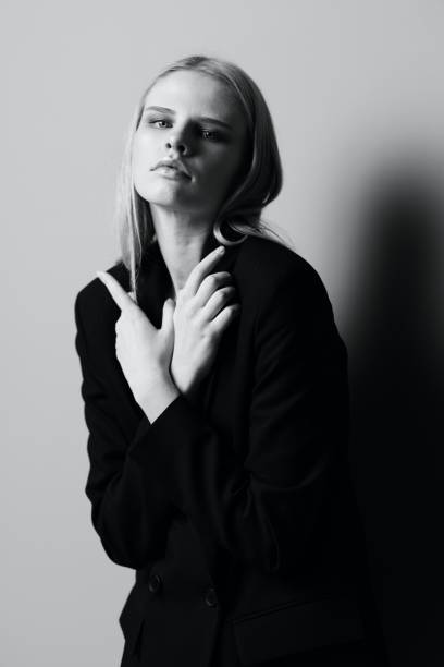 istock A stylish professional model crosses her arms on her chest and holds a jacket while posing in the studio. Fashionable stylish photo. Concept for clothing brands 2148065388