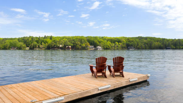 istock Two Adirondack chairs rest on a wooden dock 2148066172