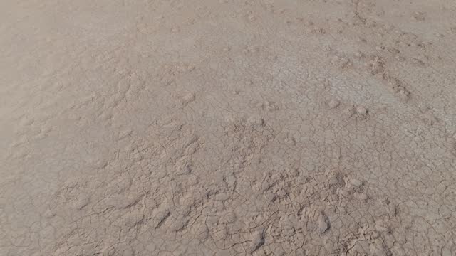 Drone clip showing wide expanse of dry and cracked ground in outback desert in WA, Australia