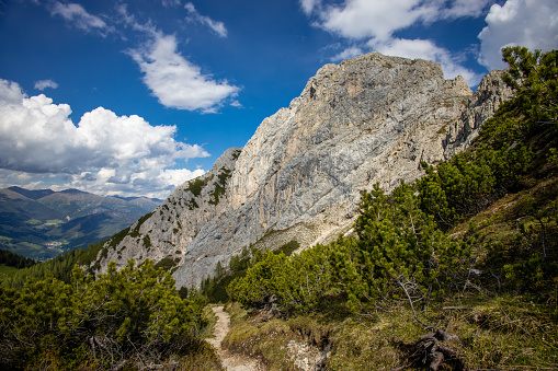 Dolomites mountains, Alpi Dolomiti beautiful scenic landscape in summer. Italian Alps mountain summits and rocky peaks above green valley alpine scene