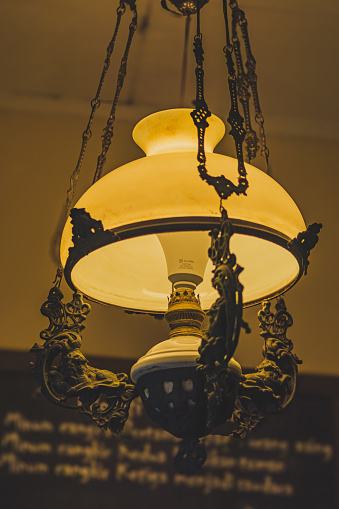 the Javanese traditional chandelier lamp is turned on. and it has a yellow light.