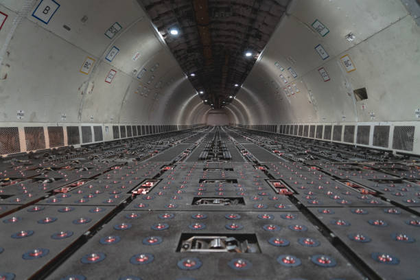 Expansive overview of the main cargo compartment of a commercial cargo aircraft. The spacious interior is empty, allowing viewers to appreciate the scale and capacity of these vital transportation vessels. Ideal for illustrating logistics, air freight, and transportation concepts.