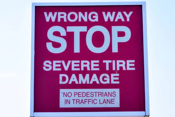 Red wrong way stop severe tire damage sign