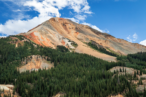 Summer landscape of Red Mountain in the Colorado Rocky Mountain of Colorado, USA with blue sky and clouds.