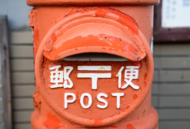 A round mailbox with the word ``post'' written in Japanese.