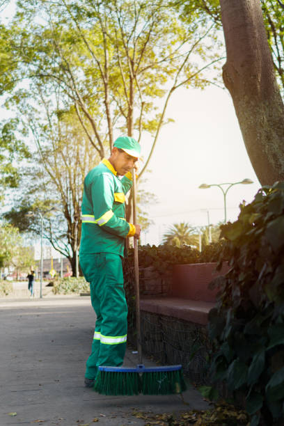 istock a worker sweeping the streets in a park 2148078318