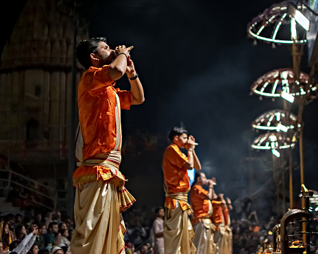 Varanasi, Uttar Pradesh, India - March 21st, 2024: Priests performing Ganga aarti on banks of holy river Ganges in one of the oldest living cities of World and spiritual capital of India, Varanasi.