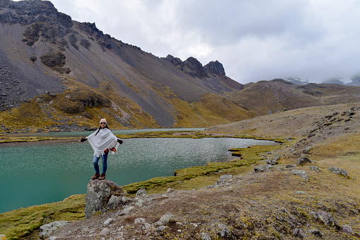 Woman Seven Lakes of Ausangate Hiking in the Andes with fantastic views of glacial peaks and alpine lakes - Pacchanta, Peru, South America