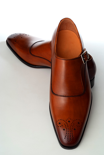 High angle view of brown leather men's shoes on white background.