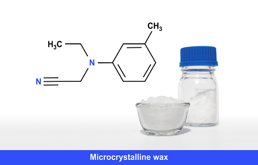 Microcrystalline wax with chemical formula on white laboratory table.