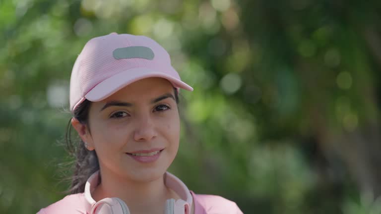 Portrait of a cute Hispanic young woman relaxing during outdoor training at a public park