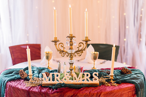 A head table for the bride and groom with candelabra candles and candlesticks with Mr and Mrs.