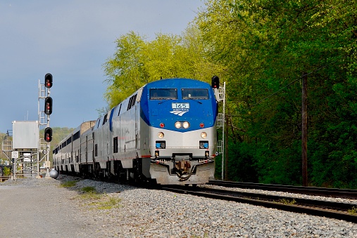 Point of Rocks, Maryland, USA - April 9, 2012: Amtrak’s “Capitol Limited” passenger train travels through the historic town of Point of Rocks along the Potomac River on a sunny day.