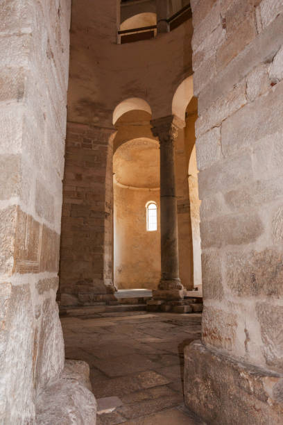 istock Interior historic building stone corridor and columns with sun in small window. 2148091543