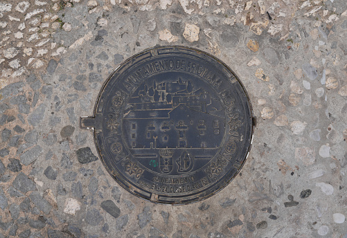 Decorative metal manhole cover in the hillside village of Frigiliana Spain