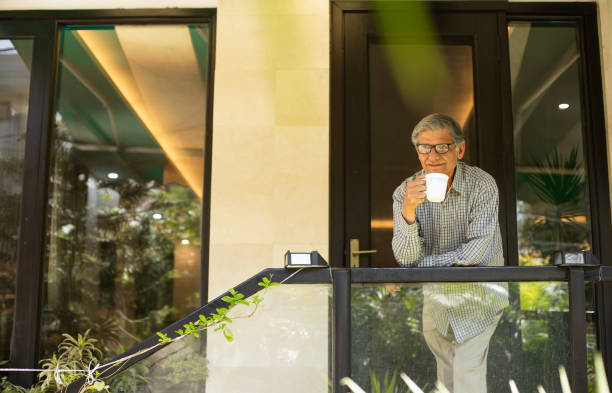 Thoughtful retired man with coffee cup at porch