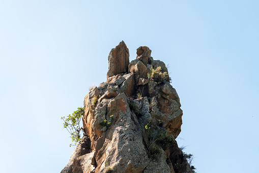 Rock cliff on blue cloudless sky background