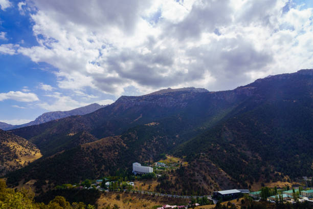 Mountains covered with grass and trees and cloudy dramatic sky on a daytime in Zaamin reserve. Mountain landscape.