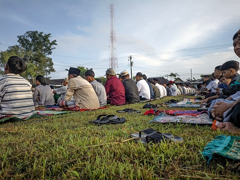 Wonogiri, Indonesia - April 10, 2024: People wait to perform Eid prayers at the Baturetno soccer field to celebrate the Eid holiday for Muslims in the morning