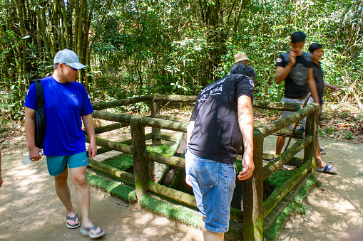 Ho Chi Minh City, Vietnam - ‎November 1, 2023 : Tourists Visit A A Booby Trap At Cu Chi Tunnels. The Cu Chi Tunnels Are A Network Of Underground Defense Tunnels.