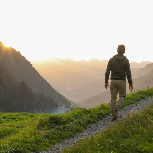 istock Mature man walks through alpine field at sunrise 2148097979
