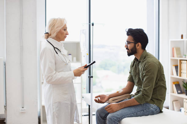 istock Bearded man receiving chemotherapy looking at nurse with tablet. 2148098753