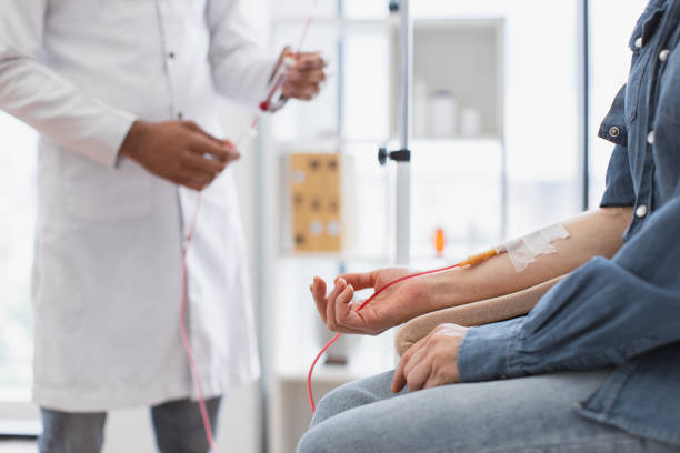 cropped view of caucasian senior woman making blood transfusions. - iv pump imagens e fotografias de stock