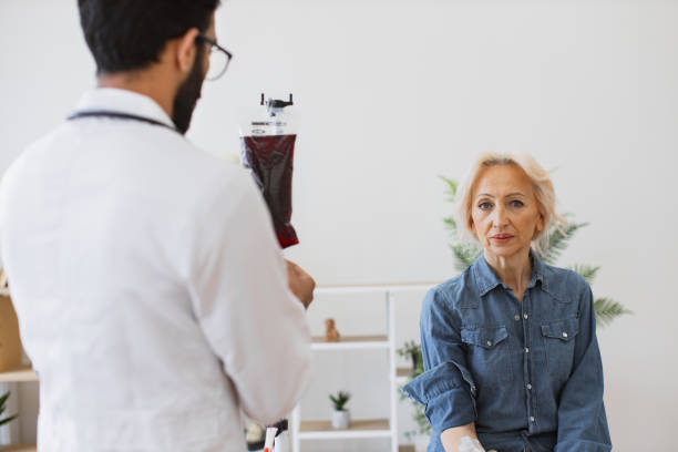 caucasian senior woman making blood transfusions. - iv pump imagens e fotografias de stock