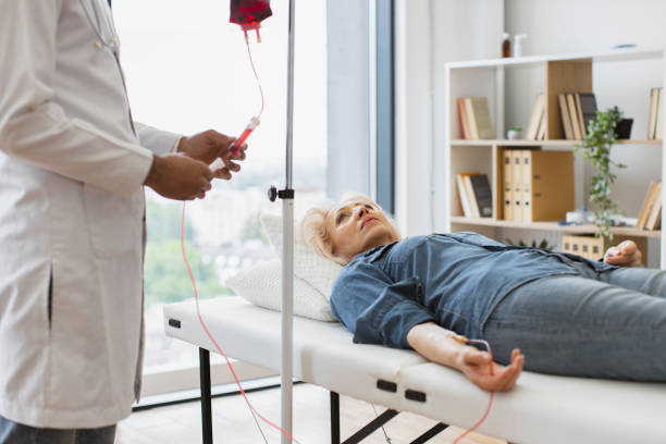 cropped view of caucasian senior woman making blood transfusions. - iv pump imagens e fotografias de stock