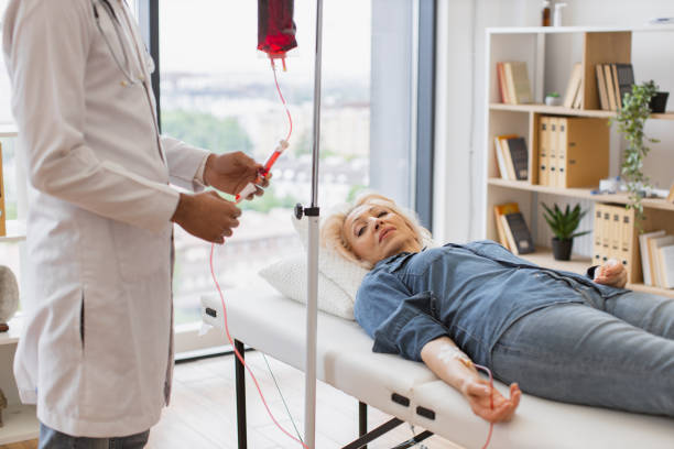 general practitioner checking tubes which blood flows of female. - iv pump imagens e fotografias de stock