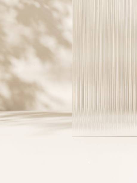 Clean fluted reeded glass in dappled sunlight, tree leaf shadow on white floor