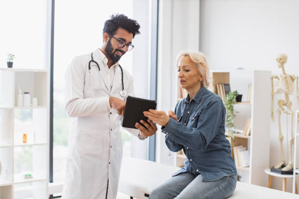 istock Adult bearded physician giving recommendations and using tablet. 2148102250