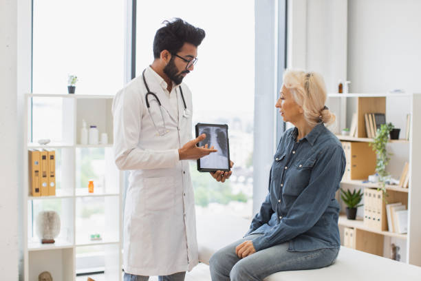 istock Bearded male in lab coat holding tablet with MRI scan. 2148102270